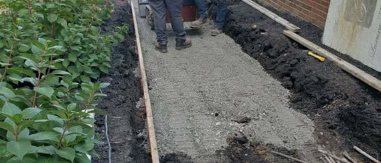 Trenching and drainage work alongside a house