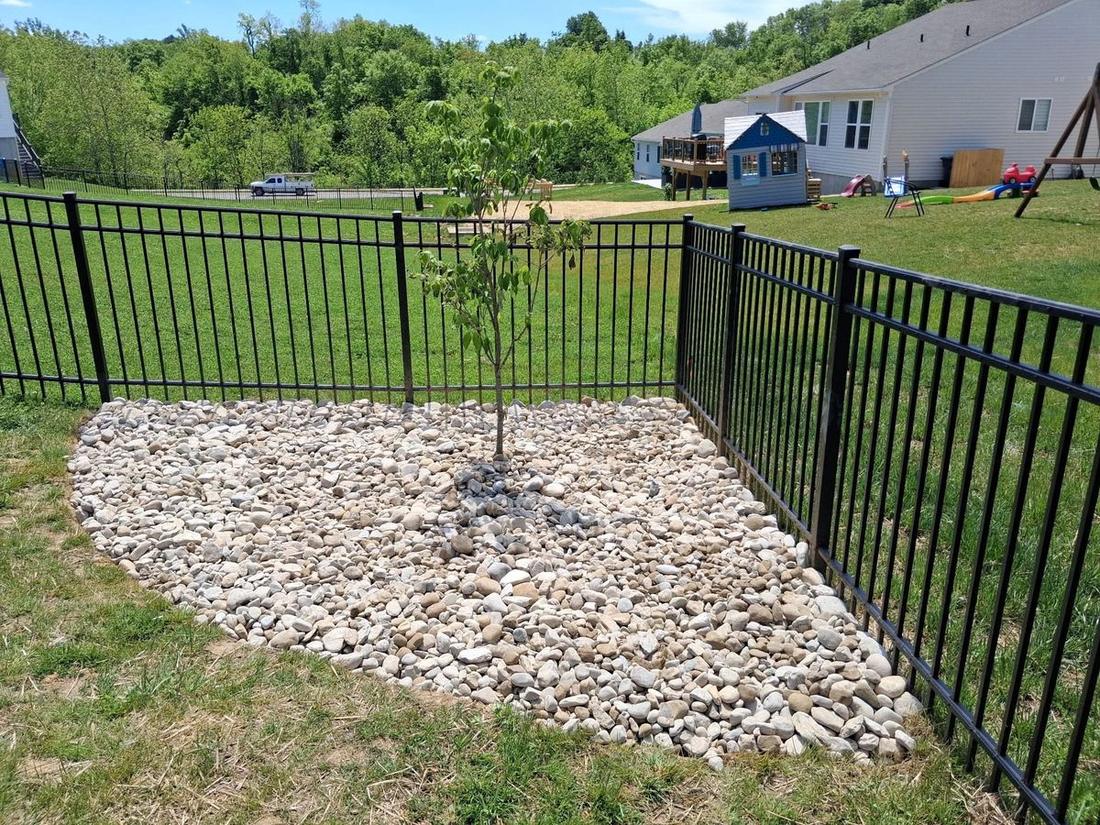 River rock bed and fenced planting